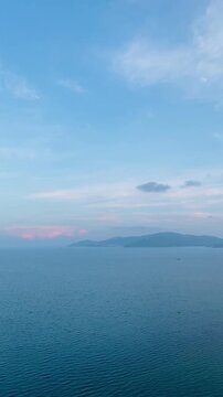 Vertical aerial view of Nha Trang north bay calm blue sea and islands at sunset in Vietnam