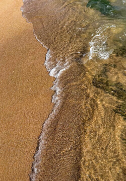 Aerial view of the shoreline at Sea-View Beach with golden sand and clear water waves washing onto the coast in Karachi, Sindh, Pakistan.
