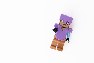 Naklejka premium Lego Minecraft Steve mini-figure in purple clothes and helmet, shot isolated on a white background with room for copy space. Bradford, UK Oct 2 2026