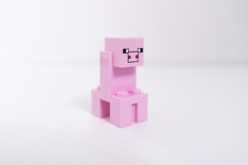 Naklejka premium Lego Minecraft pink pig mini-figure shot isolated on a white backgound. Bradford, UK Oct 2 2026