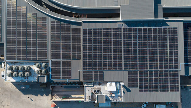 Aerial view of a commercial building roof covered with extensive solar panels, showcasing sustainable energy infrastructure in Oudtshoorn, Western Cape, South Africa.