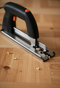Home improvement and diy renovation, electric staple gun on wooden table for carpentry and construction projects with wood debris and sawdust