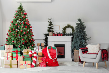 Obraz premium Interior of light living room with fireplace, Santa bag and Christmas trees