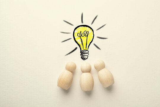 Wooden human figure and a light bulb drawing on a white background.
