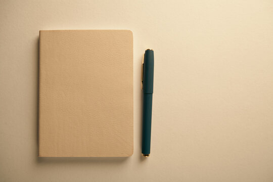 Notebook and pen on white background, soft focus and vintage tone