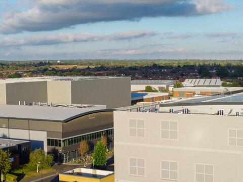 Aerial view of a large data center complex with industrial buildings, rooftops, and surrounding greenery, United Kingdom.