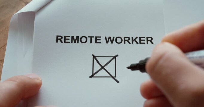 Close-up of a person using a black marker to check a checkbox labeled Remote Worker on a printed paper. Concept of remote work, working from home, flexible employment, telecommuting and modern workpla