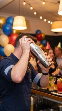 Professional bartender shaking a cocktail shaker at a birthday party  