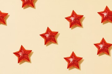 Obraz premium Foil stars with crinkled metallic textures scattered on a smooth cream background, providing ample copy space for holiday designs