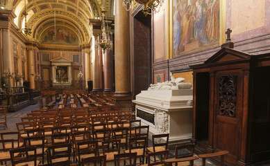 Obraz premium Neoclassical nave featuring columns, rows of chairs, a wooden confessional, and a large white marble cenotaph monument in Rennes Cathedral located in Brittany, France.