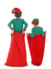 Obraz premium Cute little children in elves costumes with Santa bags isolated on white background, back view