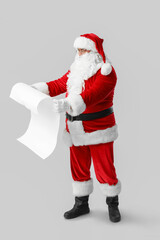Obraz premium Santa Claus with reading letter on grey background