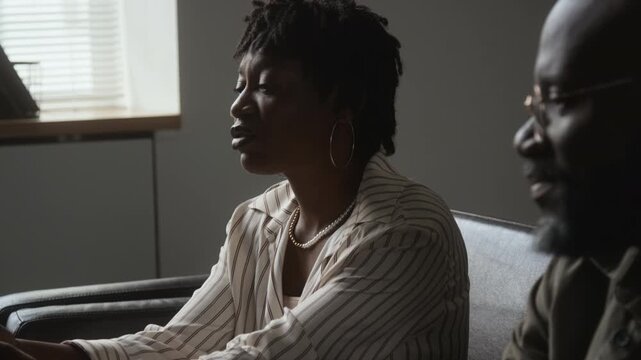 African American woman rejecting partner touch during relationship conflict, sitting frustrated on sofa. Perfect for couples therapy counseling, divorce advice, and mental health campaigns