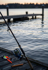 Fototapeta premium Leisure and recreation, fishing rod with reel and floats on a wooden pier at sunset for outdoor hobby and travel lifestyle during summer vacation