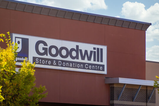 Calgary, AB, Canada. Oct 2, 2026. Exterior sign of a Goodwill store and donation centre building under a sunny blue sky.