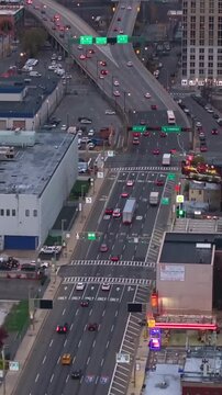 Vertical video: Cars traversing the multi lane highways and streets of New York, showcasing Brooklyn's bustling traffic flow from an aerial viewpoint