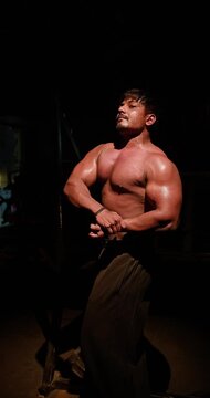 Fitness Athlete Flexing Physique and Monitoring Body Transformation in Mirror &mdash; A focus bodybuilder checks his muscular definition and overall physique while posing in front of a mirror. Ideal for fit