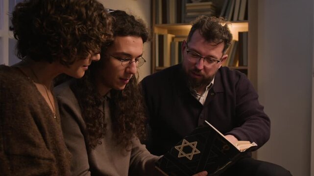Jewish Caucasian family members reading prayer book together during Hanukkah holiday. Clip fits cultural heritage campaigns, religious marketing, and educational tradition projects