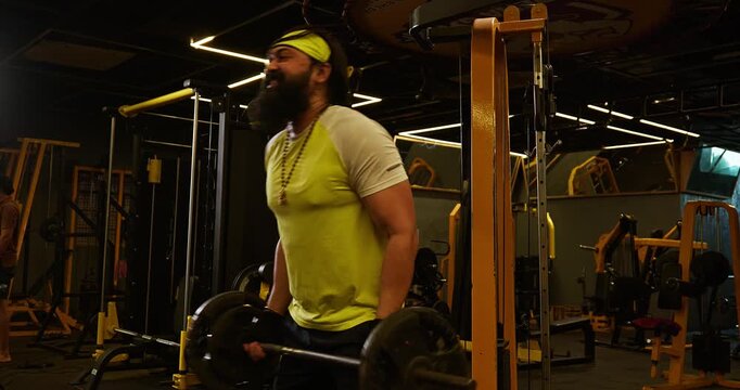 Bodybuilder Performing Intense Biceps Workout With Weights, Barbell and Rope in Gym &mdash; Muscular male athlete performs controlled biceps exercises using free weights, barbell and cable rope equipment. T