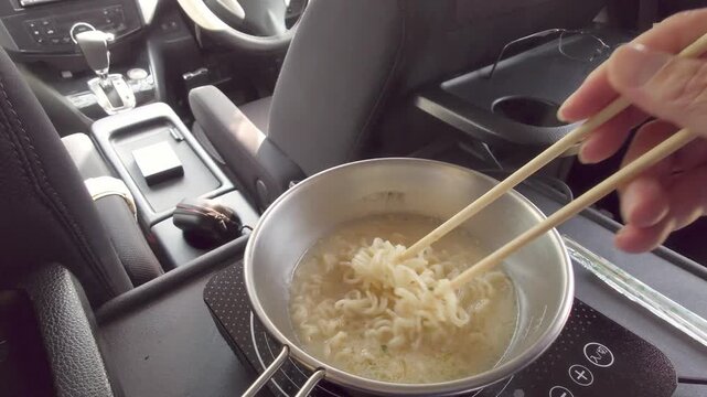 車内でポータブルIH調理器を使い作る温かいインスタントラーメンと車中飯を楽しむ車中泊の風景
