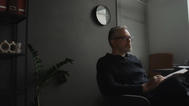 Middle aged Caucasian psychotherapist writing notes in notepad during counseling session. Video suitable for mental health awareness, psychological therapy clinics, and medical advertising