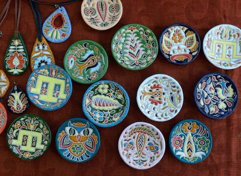Handmade crimean tatar ceramic tableware and souvenirs with colorful traditional patterns on textured fabric