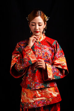 Bridal look featuring traditional Chinese red wedding attire against a black background.