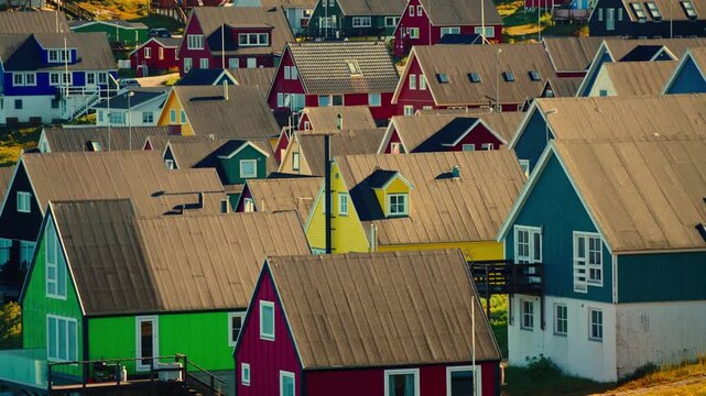 Cinematic footage of Nuuk, Greenland, captured during sunset, revealing colorful houses stretching along the Arctic coastline.