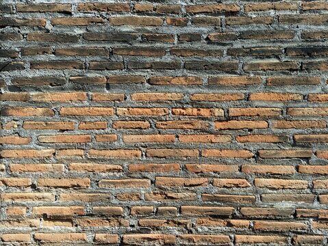 Rust texture of an old weathered red brick wall background with grey mortar lines for architecture design