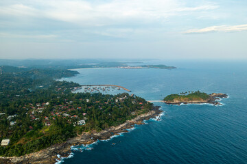 Fototapeta premium Aerial view of Nilwella fishing harbor and Blue Beach Island in Sri Lanka.
