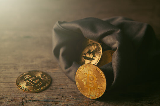 A sack of Bitcoin on a wooden background.