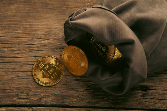 A sack of Bitcoin on a wooden background.