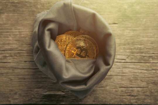A sack of Bitcoin on a wooden background.