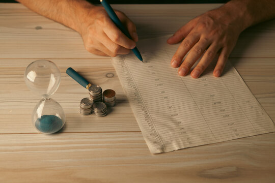 man with calculator and coins on table, closeup