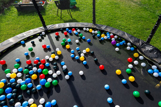 Colorful plastic balls scattered on trampoline surface