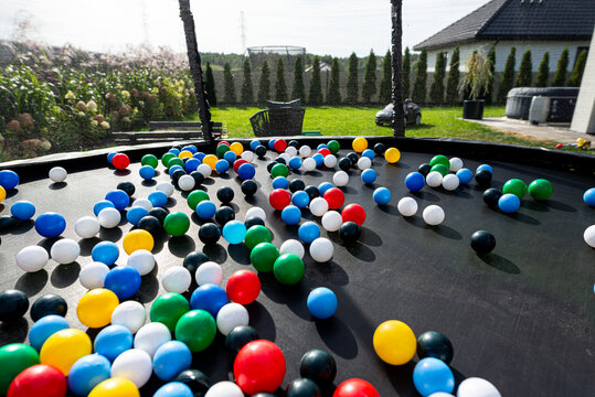 Colorful plastic balls scattered on trampoline surface