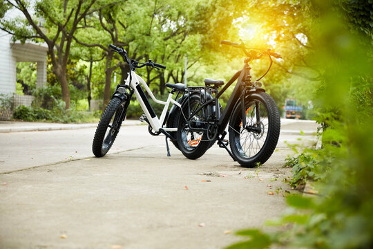 Sunset Park scene featuring two fat-tire e-bikes; showcasing an all-terrain e-bike urban commuting lifestyle.
