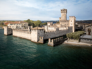 Aerial view of ancient castle rectangular towers on lake shore sunny day, Sirmione, Lake Garda, Italy © Igor