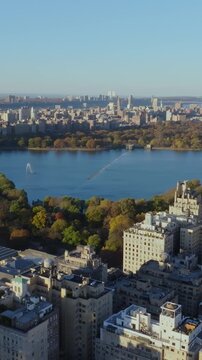 Vertical video: Aerial views showcase Central Park, highlighting Jacqueline Kennedy Onassis reservoir alongside stunning Upper West Side skyline in New York City