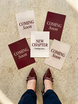 Person standing near scattered posters with coming soon and new chapter text