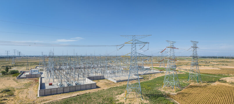Aerial Panorama of a Large High-Voltage Substation with Transmission Towers on Arid Sandy Land