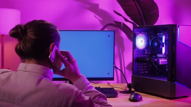 Young man has a video game stream or podcast in neon room. Male gamer playing online video games on his personal computer.
