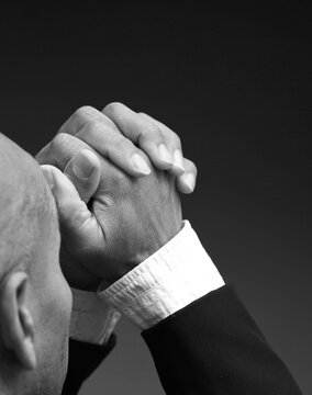 praying to god with hands showing his religious faith with God Caribbean man praying with background with people stock photo stock image