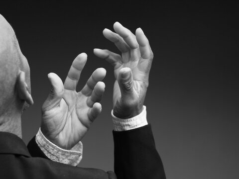 praying to god with hands showing his religious faith with God Caribbean man praying with background with people stock photo stock image