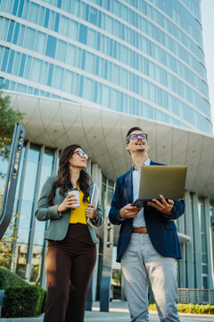 Business professionals walking discussing work outside office building