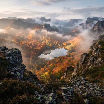 Autumn valley with a lake is shrouded in morning mist and sunlight