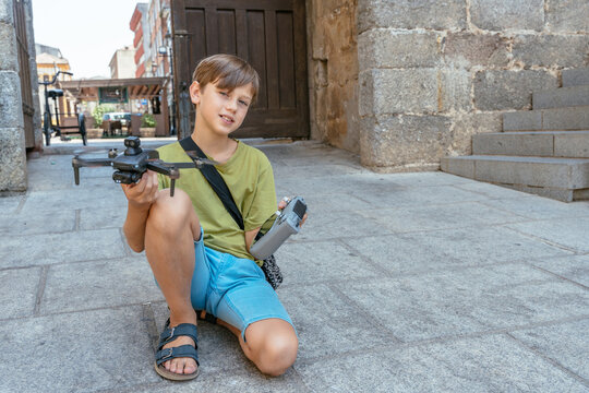 Young drone enthusiast posing with camera drone and controller in historic Spanish town