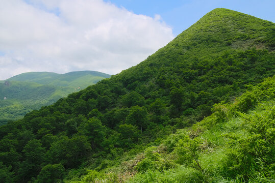 西側から望む秋田県の秣岳と遠方の栗駒山