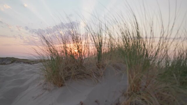 Sunset over sandy beach dunes slow motion sand sea and sun