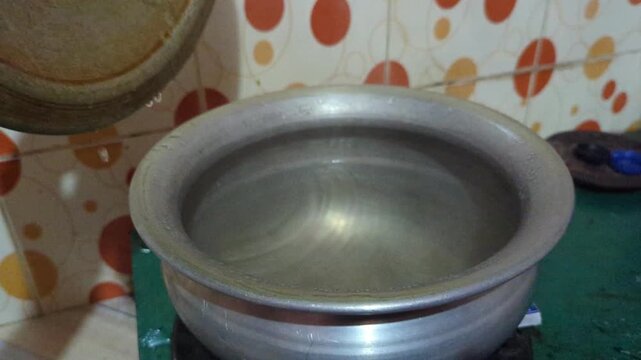 Lifting Lid from Cooking Pot with Hot Steam Release in Kitchen
